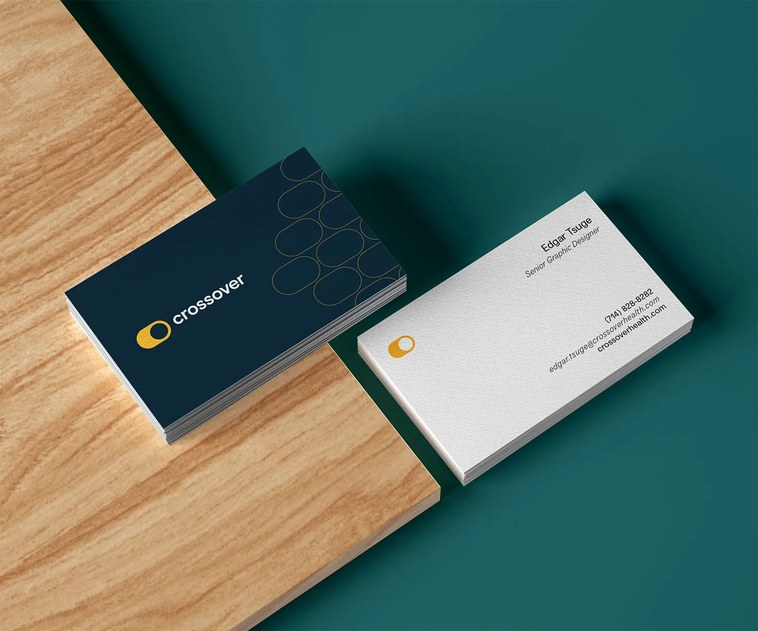 Crossover Health business cards on a wooden surface.