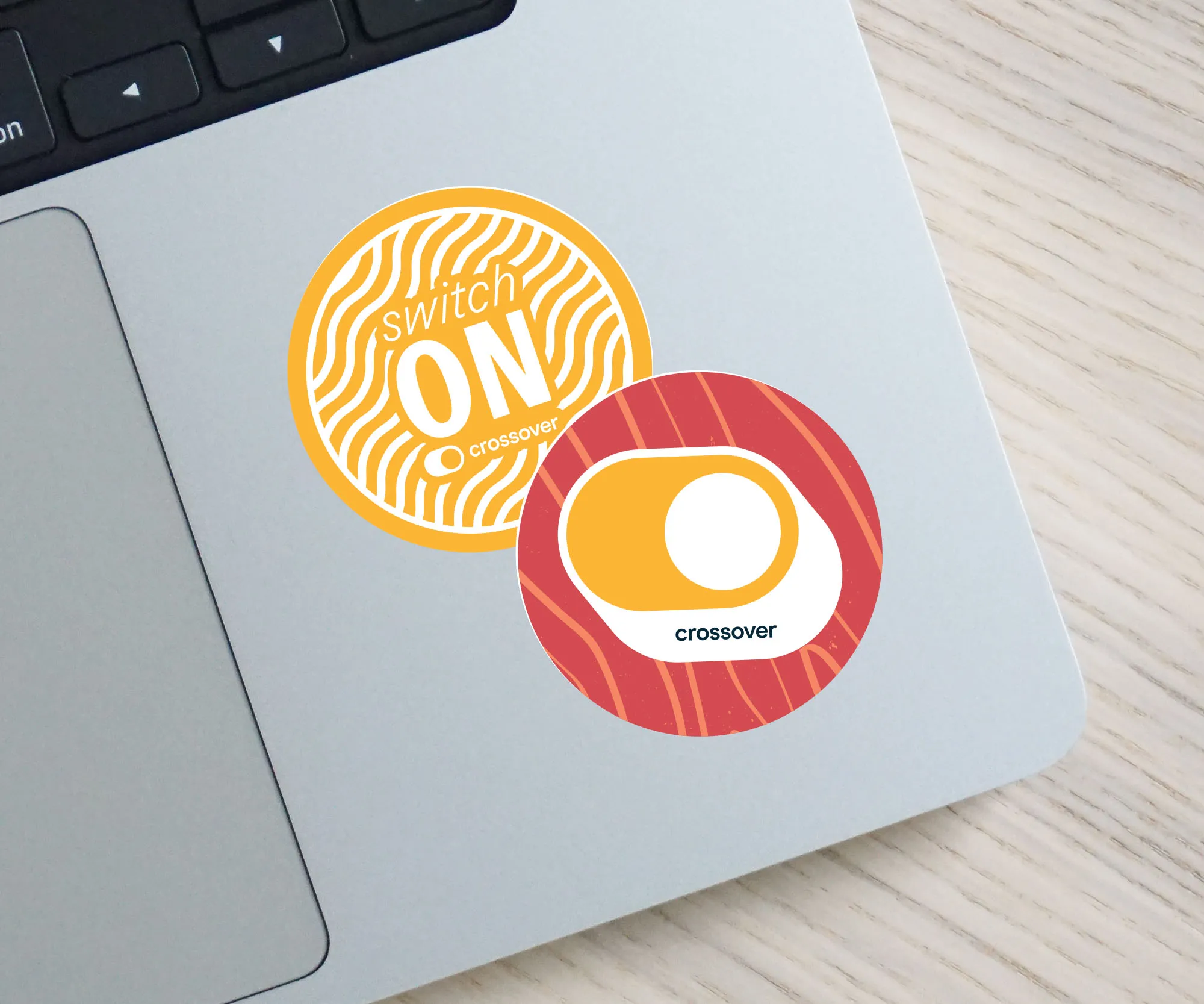 Crossover Health "Switch On" stickers on a laptop lid.
