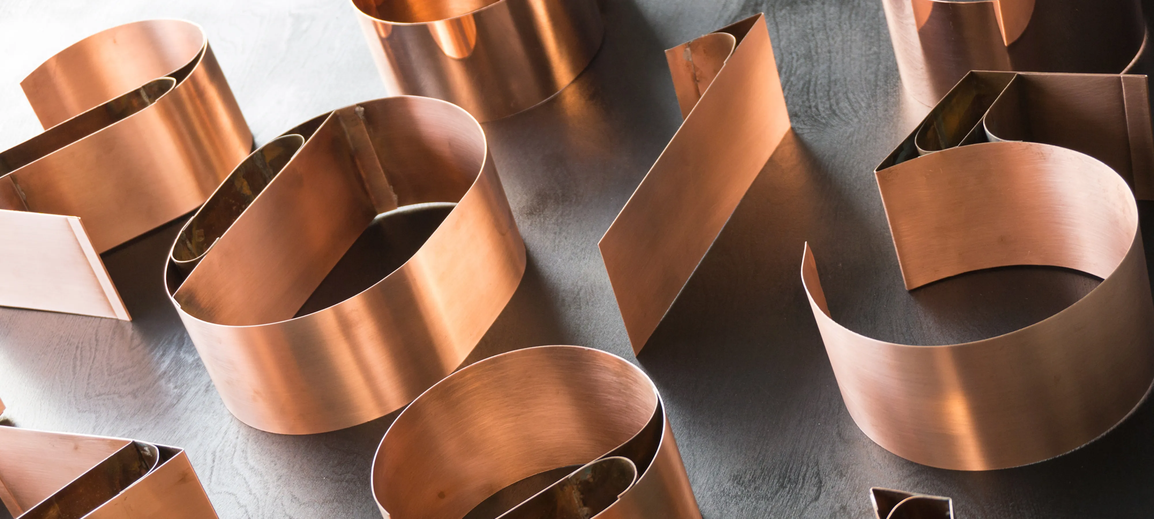 Curved copper numerals arranged across a grey surface.