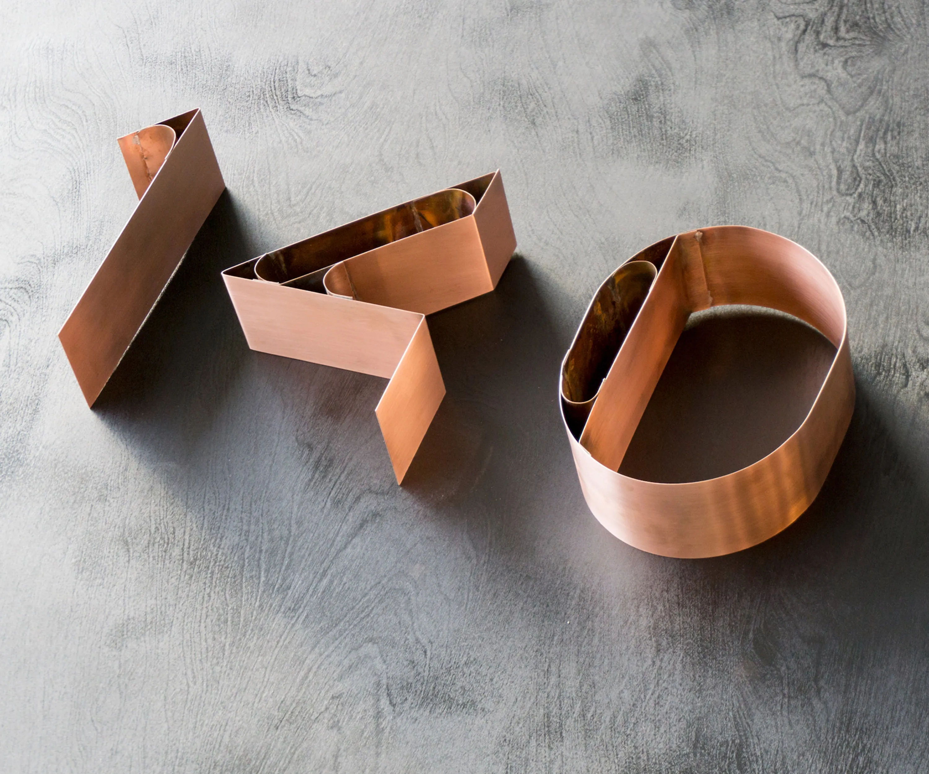 Copper house numbers laid on polished concrete.