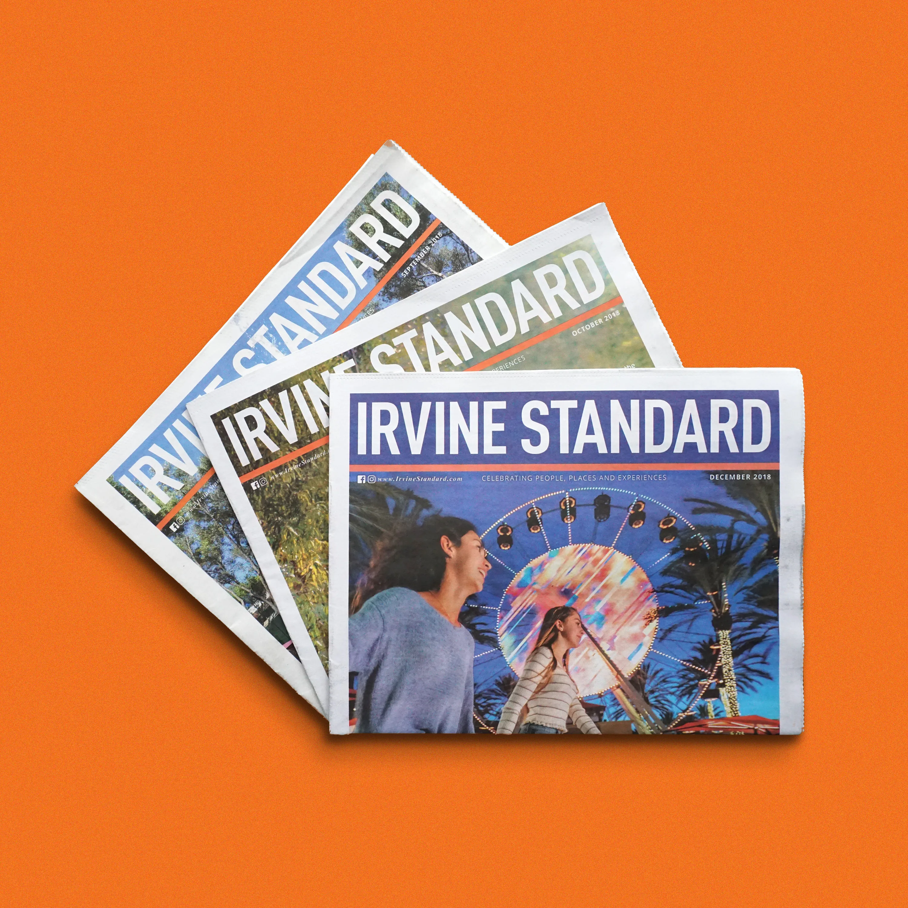 A fanned stack of Irvine Standard newspapers on an orange background.