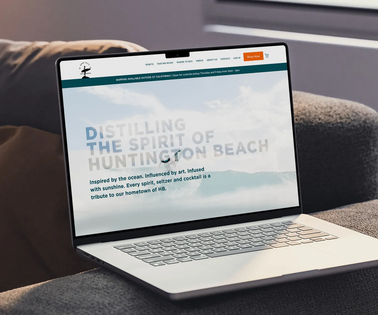 Laptop showing the Surf City Still Works site: "Distilling the spirit of Huntington Beach".