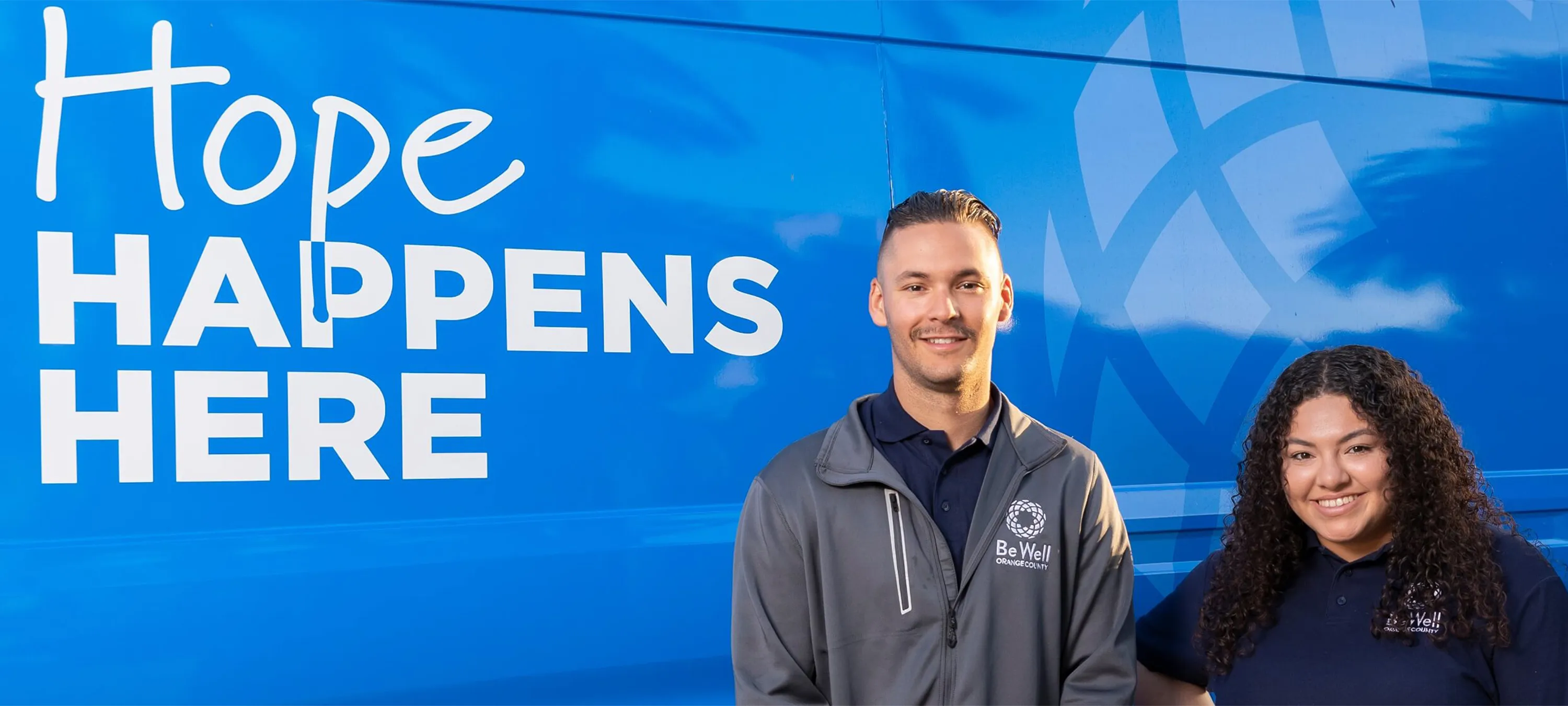 "Hope Happens Here" campaign banner with two BeWell staff members.